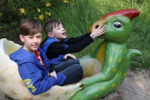 Kuba i Maciej śmieją się w skorupie jaja dinozaura.